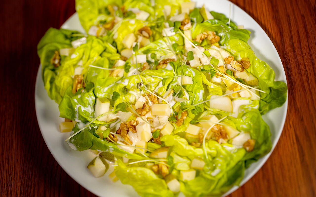 A pear and Gruyere cheese salad, with butter lettuce, buttermilk dressing, sprouts and walnuts