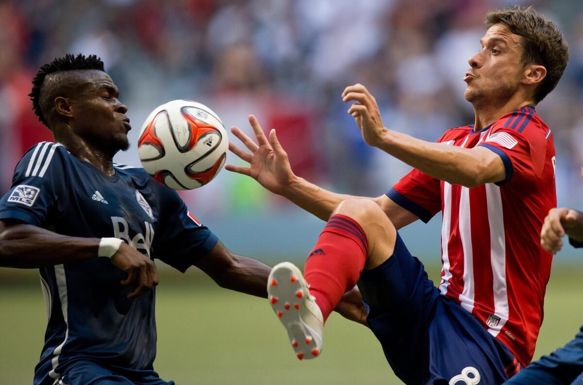 Vancouver's Gershon Koffie, left, and Chivas USA's Agustin Pelletieri, right, vie for the ball during the first half of a soccer game on July 12.