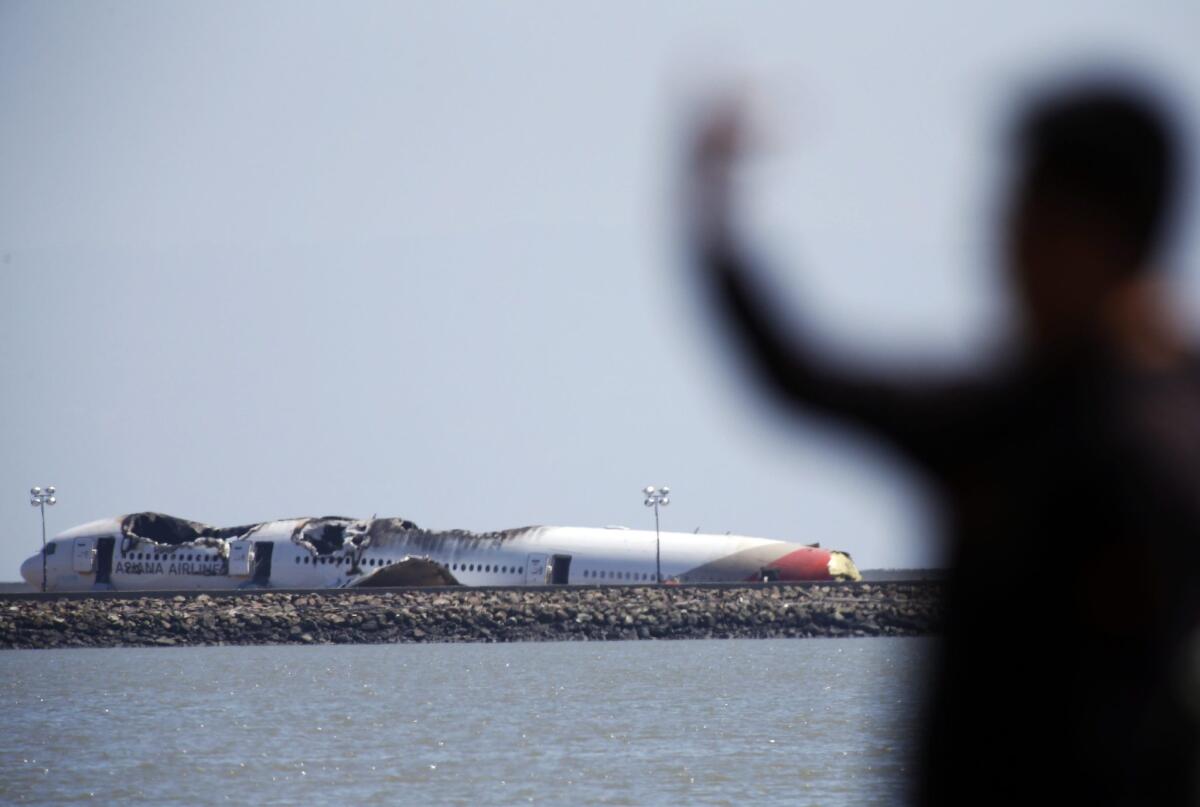Members of the public take pictures of the wreckage of Asiana Airlines Flight 214.