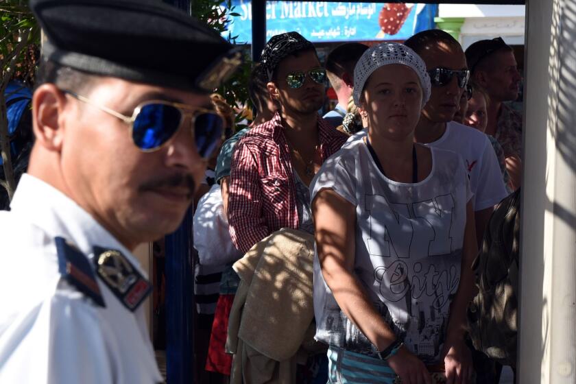 Tourists stand in line to have their belongings checked by Egyptian security forces in the Red Sea resort of Sharm el-Sheikh. Russia and Britain are increasing efforts to bring home thousands of tourists stranded there after the crash of a Russian airliner in the Sinai Peninsula disrupted flights.