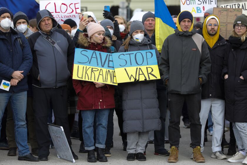 People attend a pro-Ukraine protest rally in front of the Hofburg palace in Vienna, Austria, Friday, Feb. 25, 2022 the day after Russian troops have launched their anticipated attack on Ukraine. (AP Photo/Lisa Leutner)