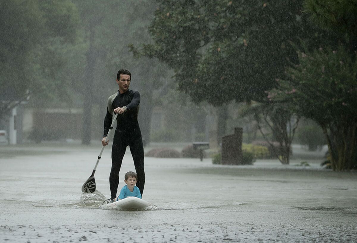Alexendre Jorge evacuates Ethan Colman, 4, from a Houston neighborhood inundated by floodwaters from Tropical Storm Harvey. (Charlie Riedel / Associated Press)