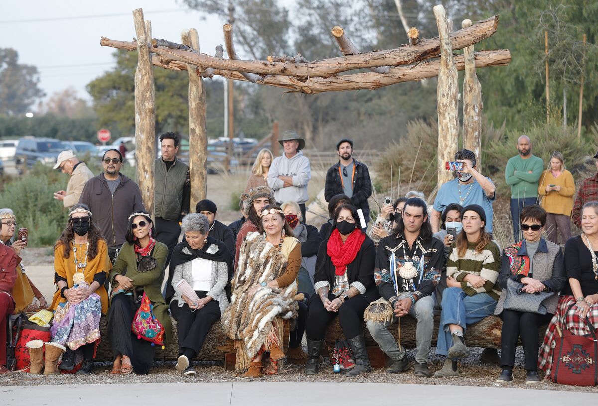 Guests listen to Native American storyteller Jacque Nunez speak during dedication of the Putuidem Village park.