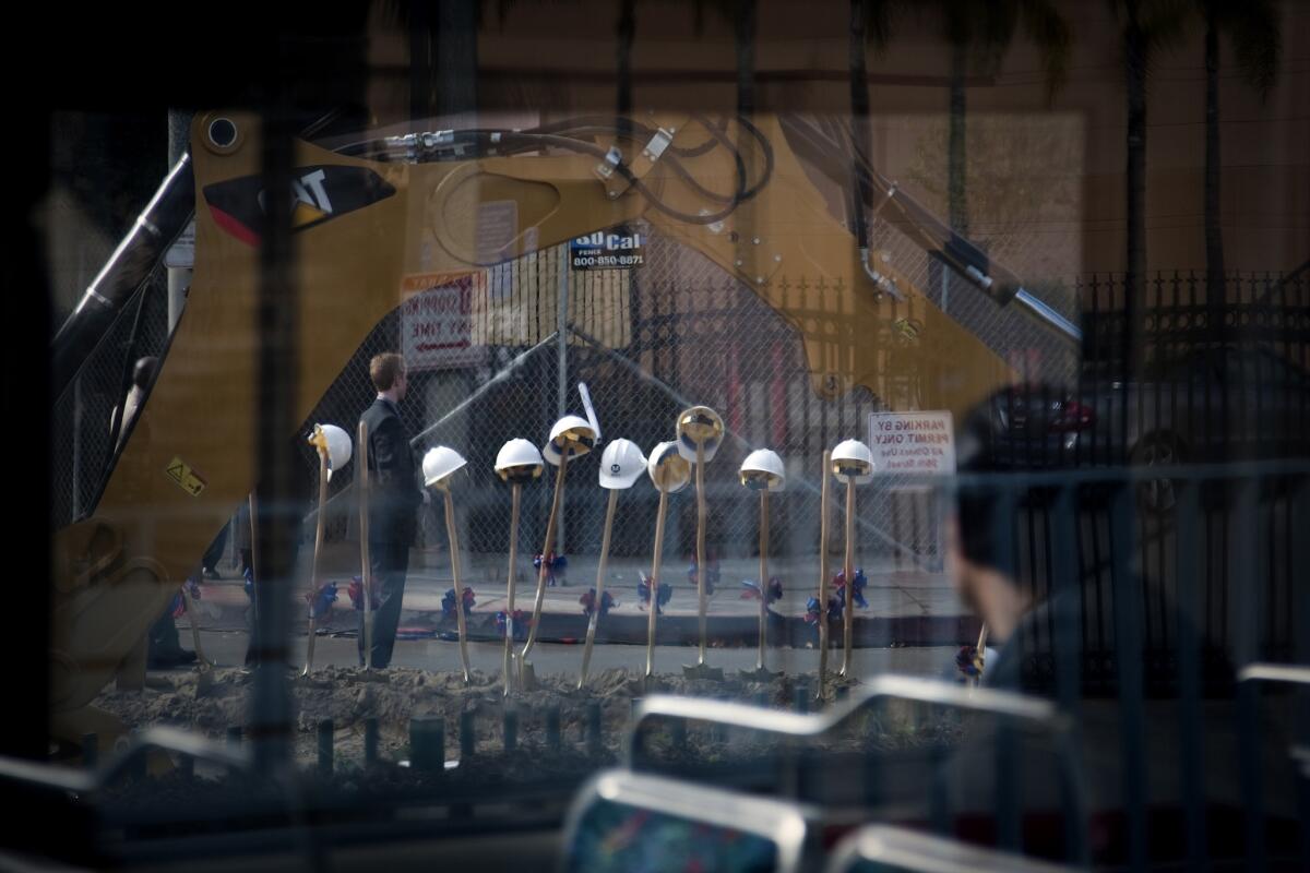 A passenger from a Metro train passes by the groundbreaking ceremony for the new Crenshaw line.