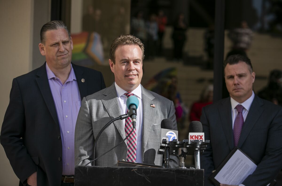 City Council member Casey McKeon, center, flanked by Mayor Tony Strickland and City Atty. Michael Gates, speaks Tuesday.