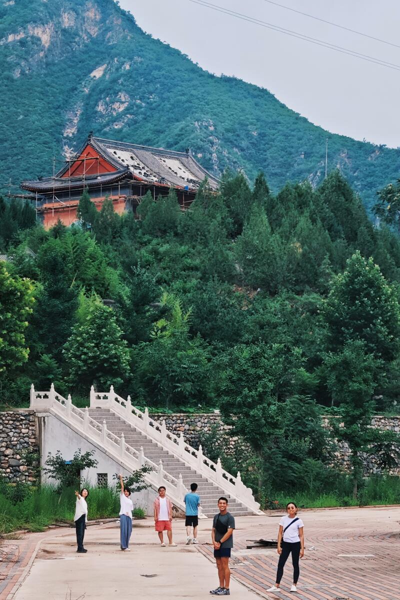 People smile near temple steps.