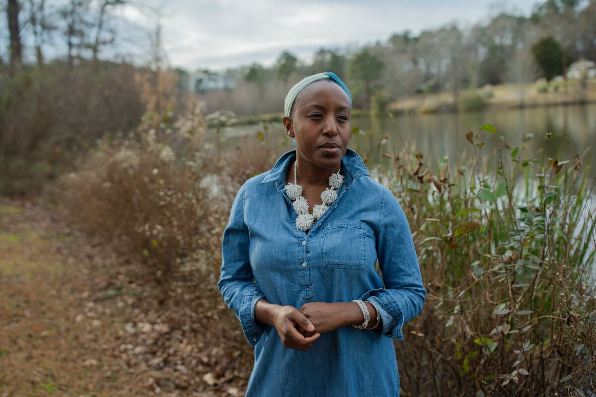 Dana Evans, 43, stands by a lake near her home in Stockbridge, Ga.