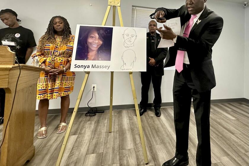 Ben Crump, the civil rights attorney representing the family of Sonya Massey, stands next to a diagram from the slain woman's autopsy on Friday, June 26, 2024, in Springfield, Ill., and gestures to show the downward angle in which Sangamon County Sheriff's Deputy Sean Grayson shot Massey in the face early on July 6. Massey had called 911 with suspicions of a prowler near her Springfield home. Grayson has pleaded guilty to first-degree murder and other charges. (AP Photo/John O'Connor)