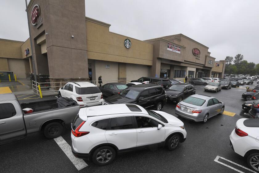 Cars are seen backed up at a Ralphs grocery store in the Woodland Hills section of Los Angeles. Widespread fear over COVID-19, the coronavirus disease, has prompted Cherokee County residents to make a run on stores, culminating in a shortage of disinfectant supplies. (AP Photo/Mark J. Terrill)