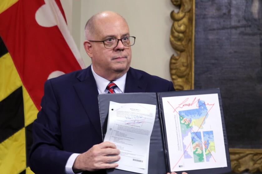 Maryland's Republican Gov. Larry Hogan shows a copy of the redrawn congressional map approved by the General Assembly this week, that is crossed out in red, during a news conference where he announced his veto of the plan, Thursday, Dec. 9, 2021, in Annapolis, Md. The General Assembly, which is controlled by Democrats, have the votes to override the governor's veto. (AP Photo/Brian Witte)