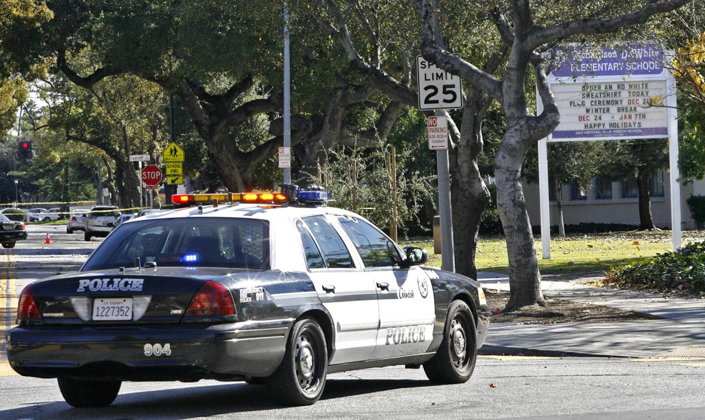 Glendale police cars block the street in front of R.D White Elementary School after the school was evacuated due to a bomb threat on Monday, January 7, 2013.
