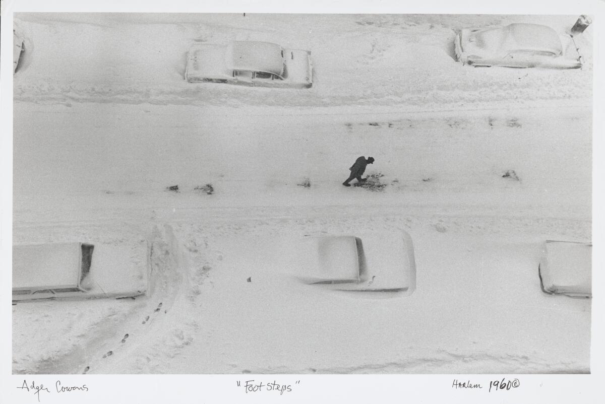 A man leaves footprints in the snow in a photograph captured from above.