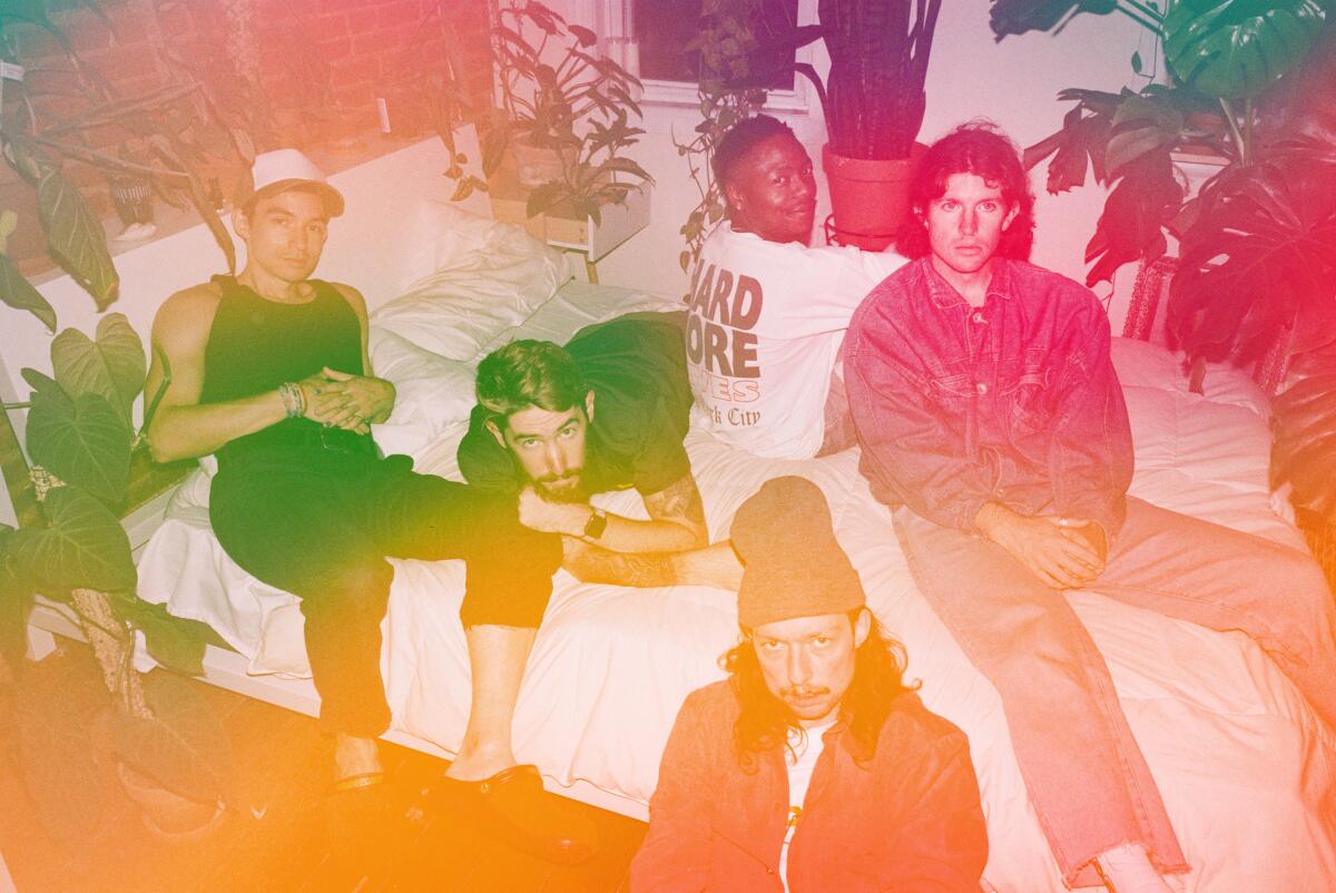 The group called Turnstile poses on a bed.