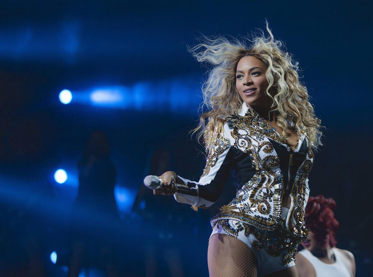 Beyoncé performs onstage holding a microphone