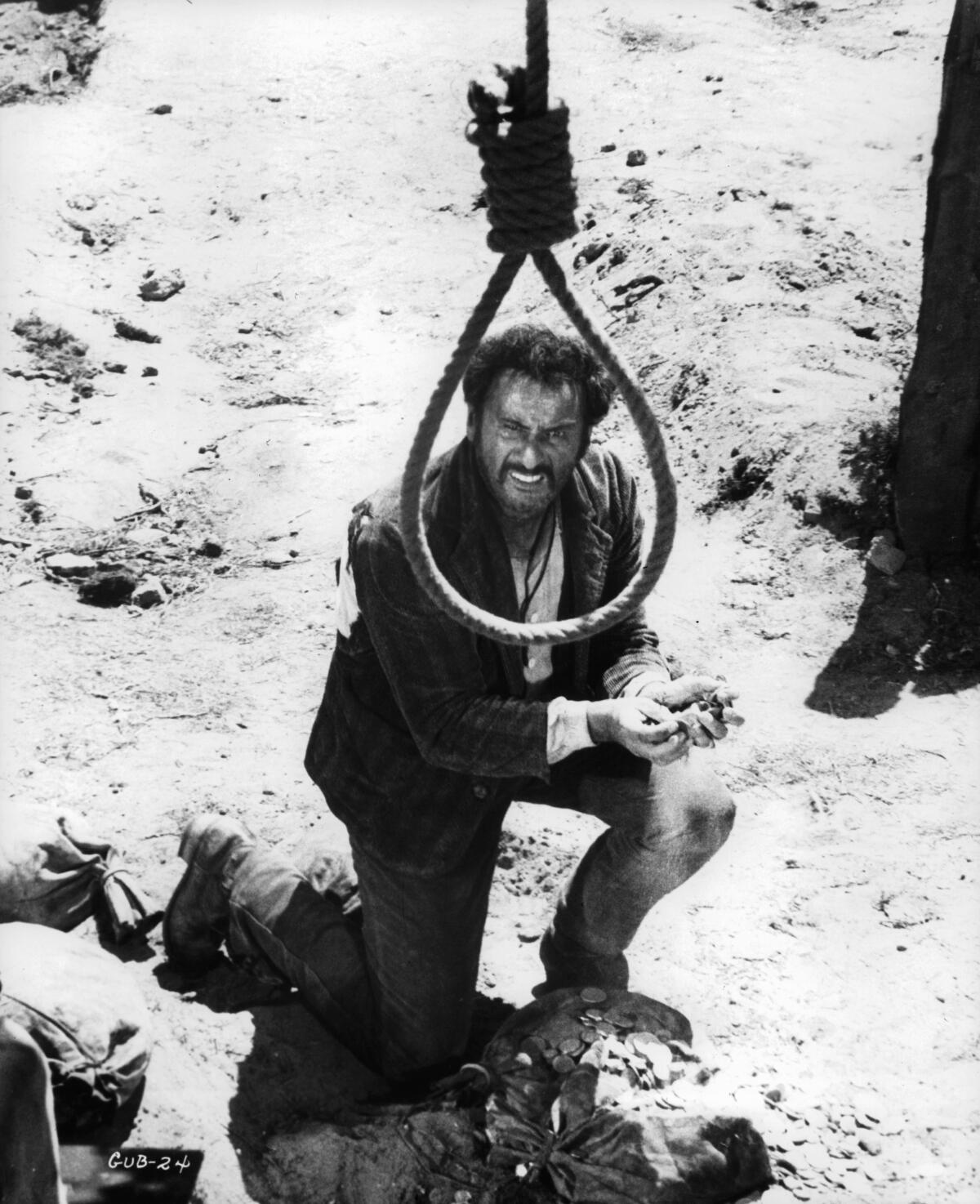 A cowboy kneels on the ground looking up at a noose, which frames his head in the shot from "The Good, the Bad and the Ugly."