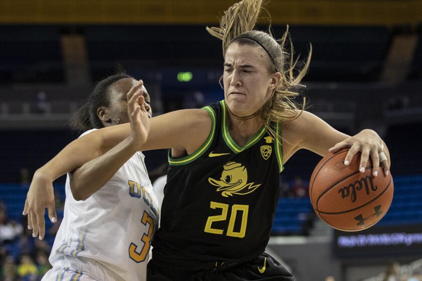 LOS ANGELES, CALIF. -- FRIDAY, FEBRUARY 14, 2020: Oregon Ducks guard Sabrina Ionescu (20) muscles her way past UCLA Bruins guard Kiara Jefferson (3) during 4th quarter of Pac-12 basketball game at Pauley Pavilion in Los Angeles, Calif., on Feb. 14, 2020. (Brian van der Brug / Los Angeles Times)