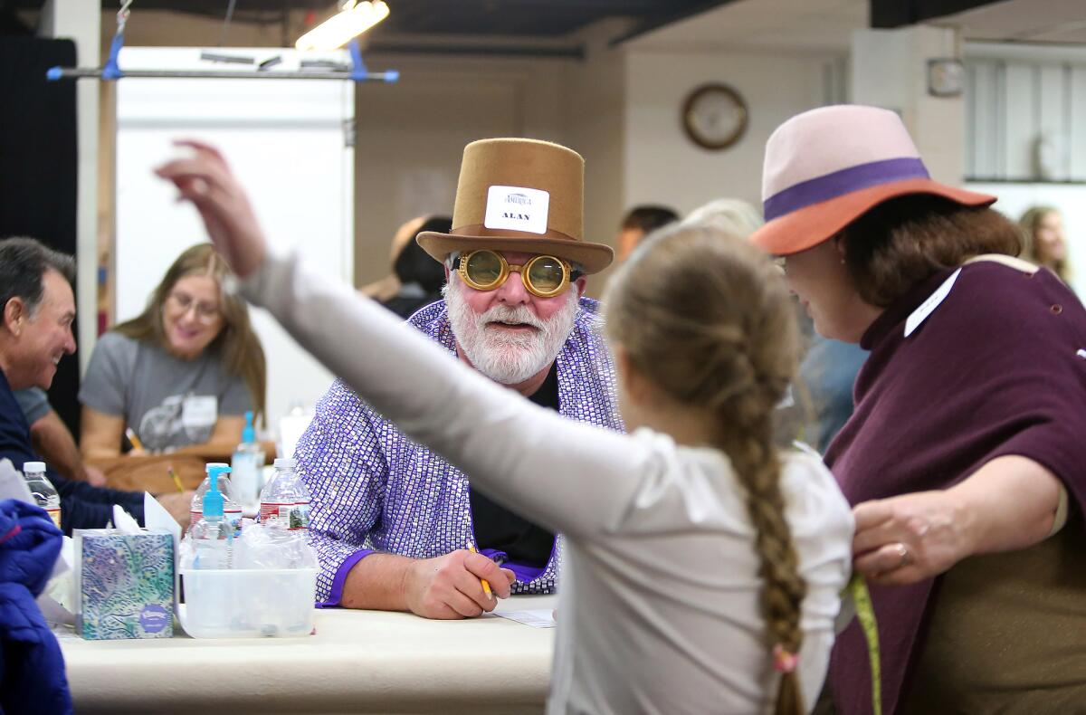 Longtime volunteer Alan Perlmutter chats with prospective cast member Arin Aral, 8, while his wife, Gail, measures her arm length Friday night during the 2020 Pageant of the Masters open casting call.