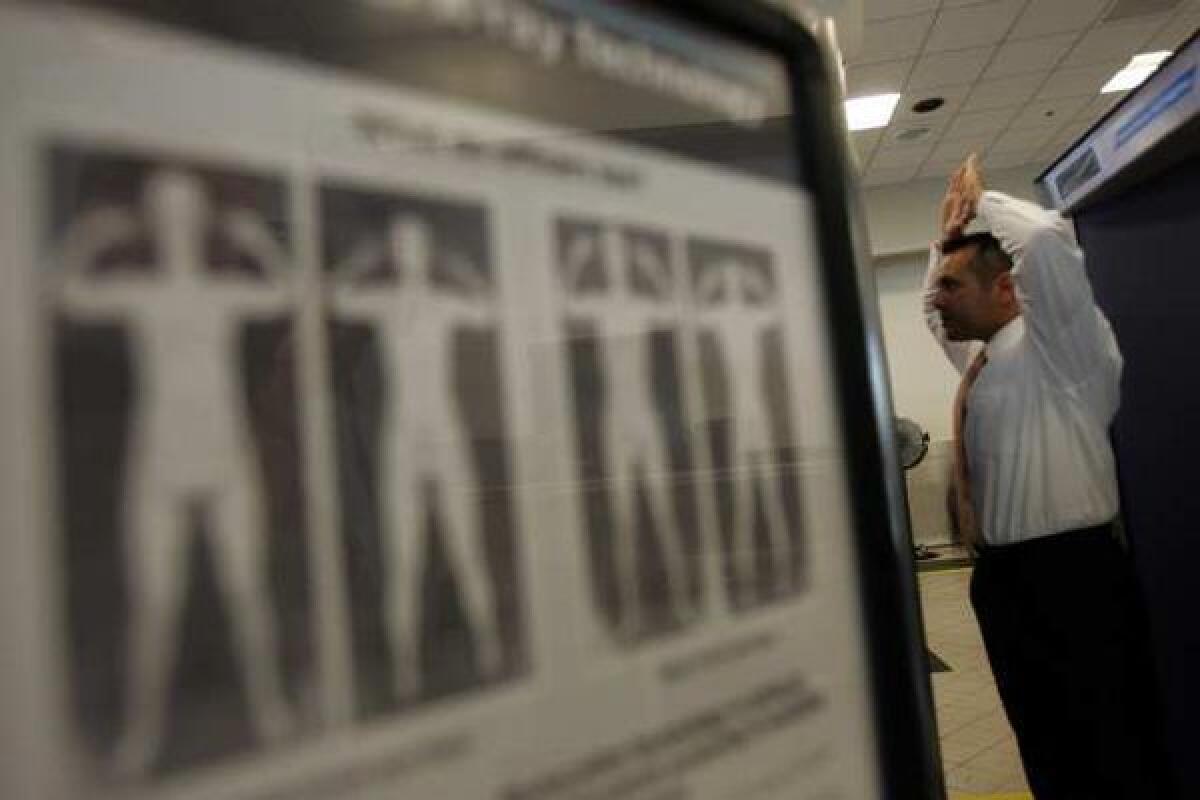 A Transportation Security Administration agent demonstrates a full-body scanner at Los Angeles International Airport.