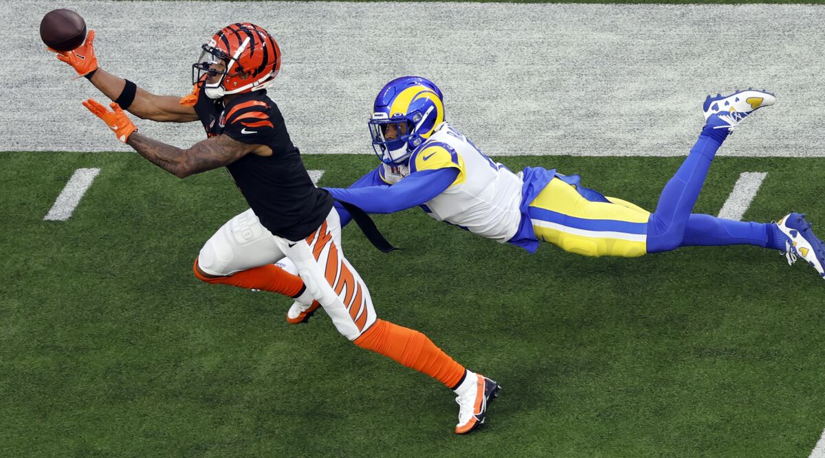 Bengals wide receiver Ja'Marr Chase makes a one-handed catch while defended by Rams cornerback Jalen Ramsey.