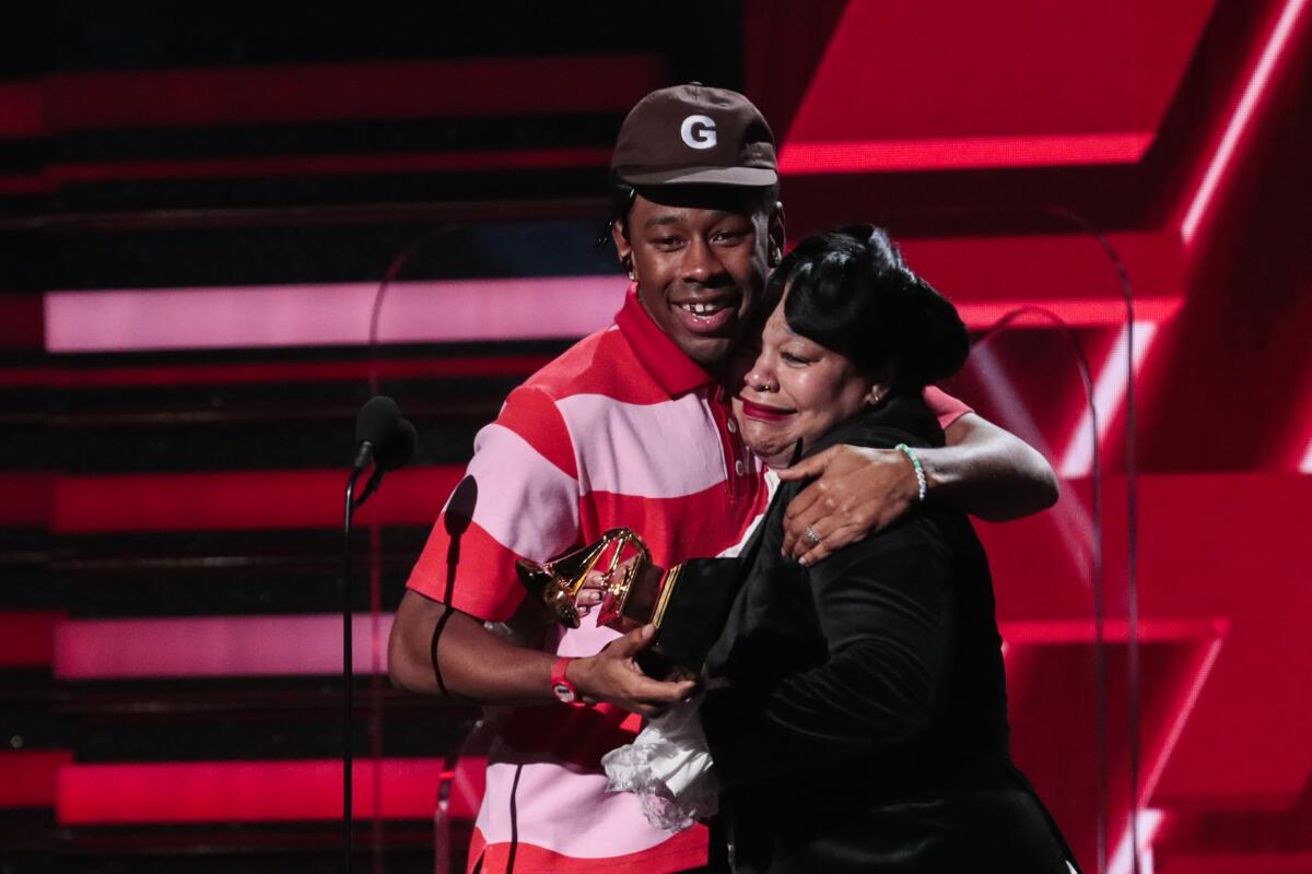 Tyler, the Creator and his mom accept an award at the 62nd Grammy Awards.