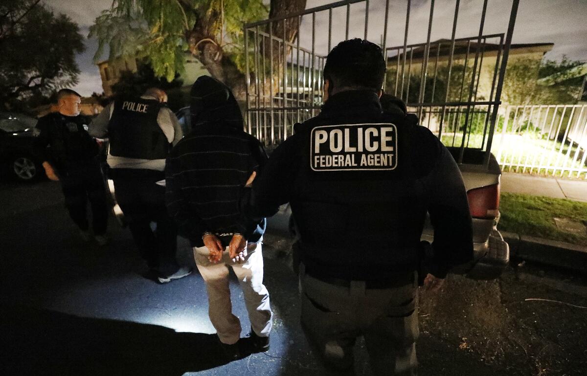 ICE officers make a predawn arrest in Los Angeles.