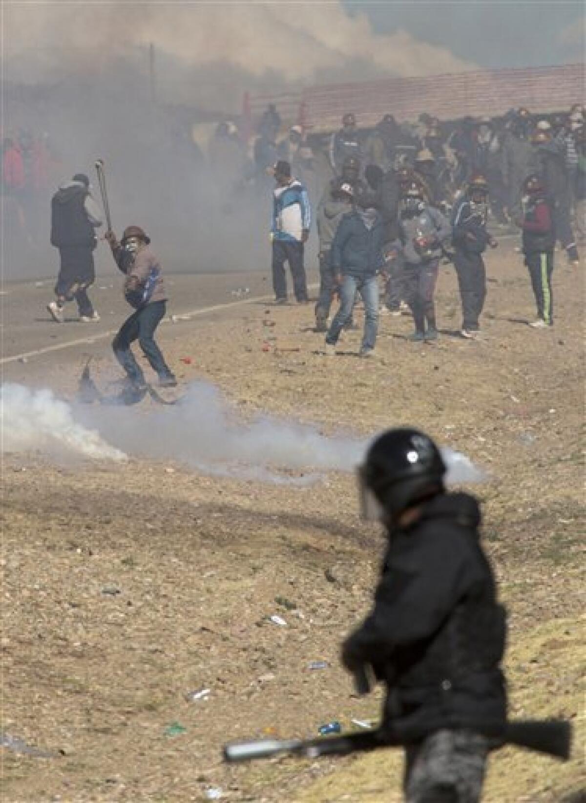 Mineros independientes chocan con la policía y huyen de gases lacrimógenos durante protestas en Panduro, Bolivia.