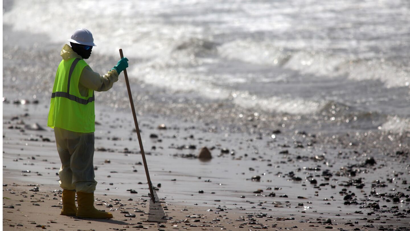 A Patriot Environmental Services worker looks out May 27 over the Pacific Ocean during cleanup at Refugio State Beach.