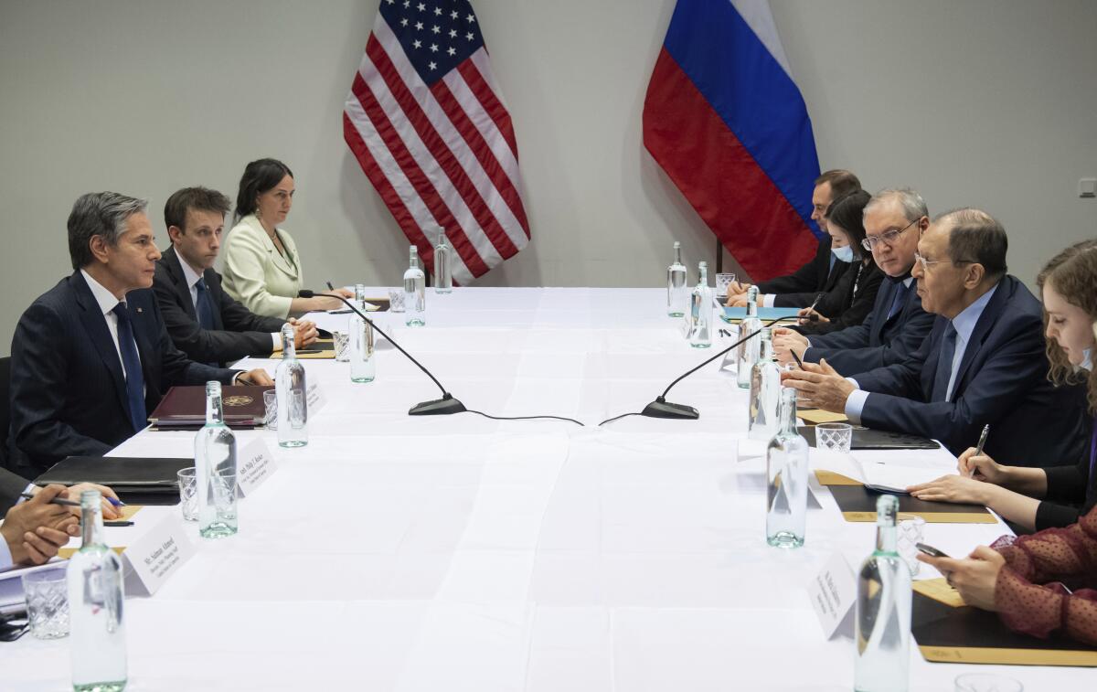 U.S. and Russian diplomats face each other at a table. 