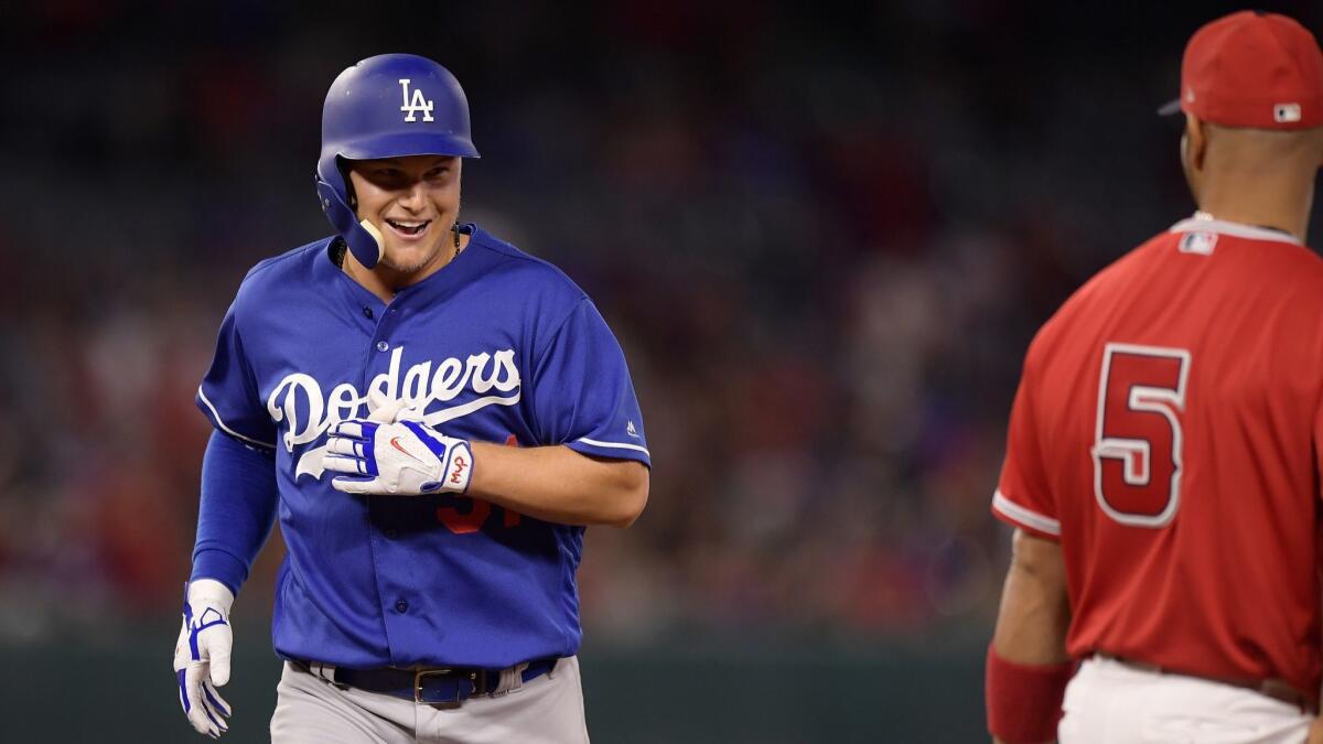 Dodgers' Joc Pederson, left, smiles at Angels first baseman Albert Pujols after being thrown out at second while trying to stretch a single into a double during the fifth inning.