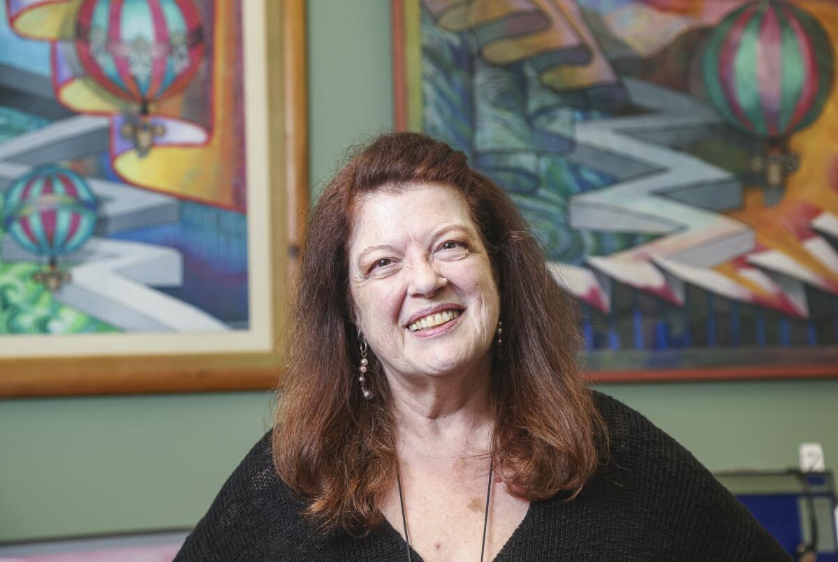 Artist Patricia Frishcer poses for photos with some of her work on display 