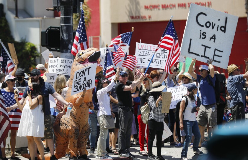 Protesters stand along Mission Boulevard in Pacific Beach during a "Day of Liberty" rally on April 26, 2020. The protesters were against the government shutdown due to the coronavirus.