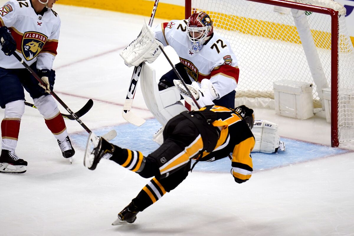 Pittsburgh Penguins' Evgeni Malkin (71) falls as he attempts to get a shot off in front of Florida Panthers goaltender Sergei Bobrovsky (72) during the first period of an NHL hockey game in Pittsburgh, Tuesday, March 8, 2022. (AP Photo/Gene J. Puskar)
