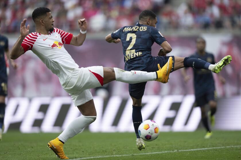 FILE - Leipzig's Benjamin Henrichs, left, challenges Mainz's Phillipp Mwene for the ball during the Bundesliga soccer match between RB Leipzig and FSV Mainz 05 in Leipzig, Germany, March 30, 2024. Defender Benjamin Henrichs has signed a contract extension through 2028 with Leipzig, one day after being named to Germany's preliminary squad for the European Championship next month. (Hendrik Schmidt/dpa via AP, File)