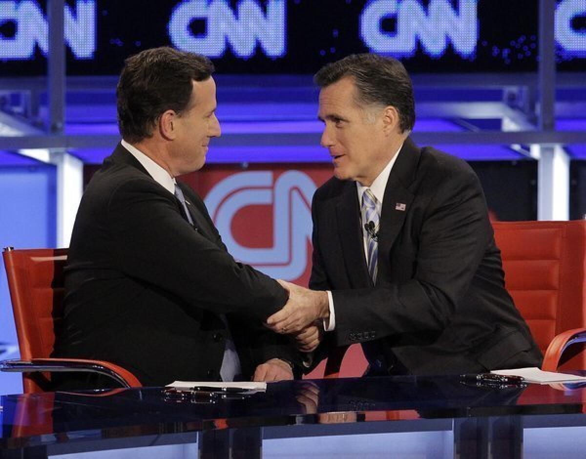 Rick Santorum and Mitt Romney talk following a Republican presidential debate Wednesday, Feb. 22, 2012, in Mesa, Ariz.