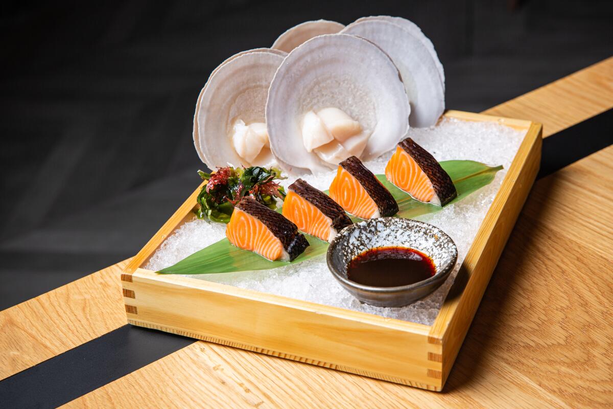 A photo of salmon and scallops served in a box of ice