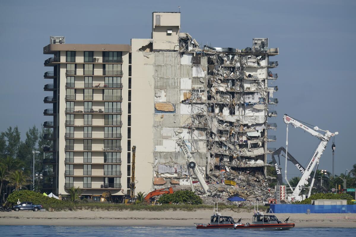 FILE - In this Thursday, July 1, 2021, file photo, coast guard boats patrol in front of the partially collapsed Champlain Towers South condo building, ahead of a planned visit to the site by President Joe Biden, in Surfside, Fla. A Miami Beach apartment building owned by Surfside Mayor Charles Burkett has given his tenants 45 days to vacate the building so extensive repairs can be completed. In addition, he said the Lois Apartments will also undergo the required 40-year inspection early, due to the Champlain Towers South collapse. (AP Photo/Mark Humphrey, File)
