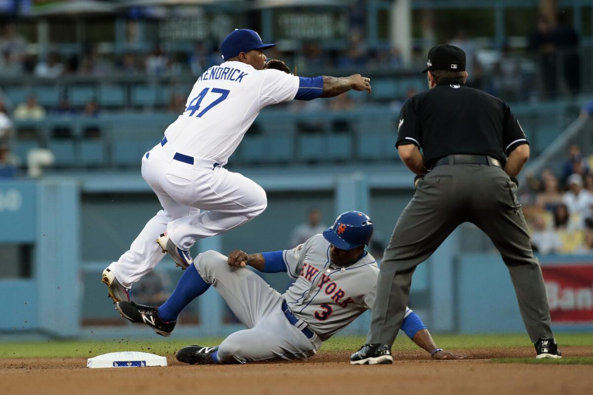 Dodgers second baseman Howie Kendrick relays a double-play ball to first as Mets base runner Curtis Granderson arrives during a National League division series game.