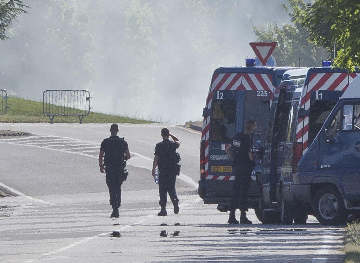 Agentes de policía hacen guardia en una carretera que lleva a la fábrica que sufrió un ataque terrorista extremista en Saint-Quentin-Fallavier, al sureste de Lyon, Francia, el 26 de junio de 2015. (Foto AP/Michel Euler)