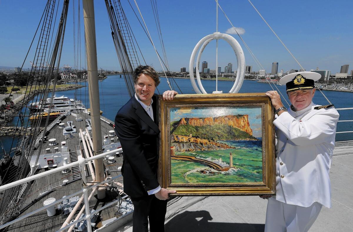 Duncan Sandys, left, great grandson of Sir Winston Churchill, and Commodore Everett Hoard hold up a painting done by Sir Winston Churchill titled "Coast Scene Near Marseilles" from the 1930s, an oil on canvas. It will be on exhibit at an art gallery aboard the Queen Mary in Long Beach from May 27 to Dec. 31, 2016.