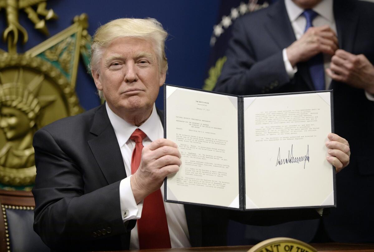 President Trump signs executive orders at the Department of Defense on Jan. 27. The one barring refugees and travel from seven majority-Muslim countries is making business more difficult, some entrepreneurs say.