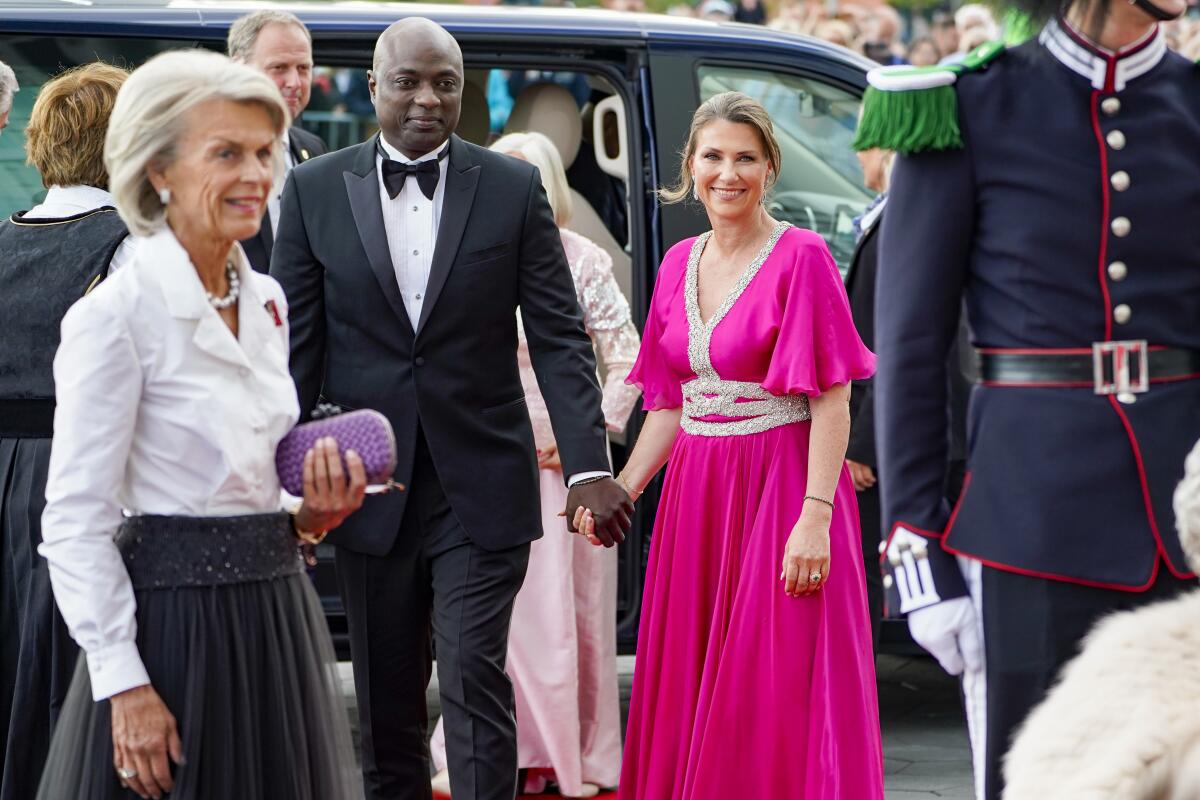 Princess Martha Louise of Norway and her fiance, Durek Verrett, hold hands as they arrive at an event.