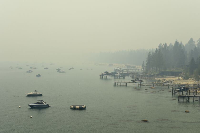 Smoke from Caldor Fire in California covers Lake Tahoe in the Incline, Nev., area on Tuesday, Aug. 24, 2021. A California fire that gutted hundreds of homes advanced toward Lake Tahoe on Wednesday as thousands of firefighters tried to box in the flames and tourists who hoped to boat or swim found themselves looking at thick yellow haze instead of alpine scenery. (Andy Barron/The Reno Gazette-Journal via AP)