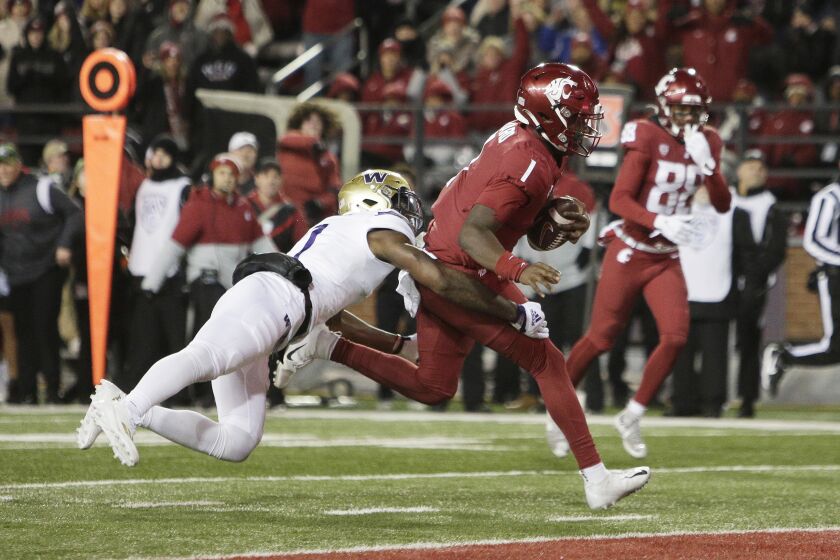 Washington State quarterback Cameron Ward (1) runs for a touchdown while defended by Washington linebacker Dominique Hampton (7) during the first half of an NCAA college football game, Saturday, Nov. 26, 2022, in Pullman, Wash. (AP Photo/Young Kwak)