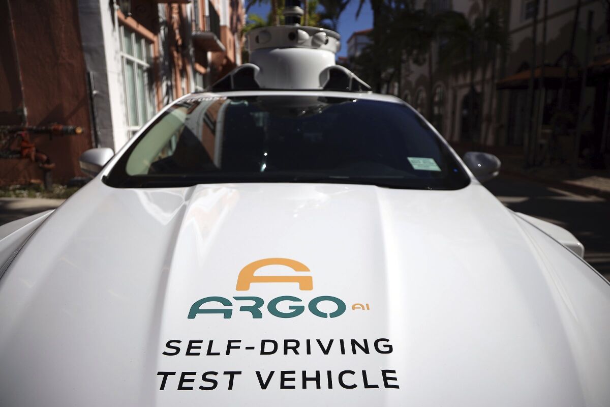 FILE - An experimental autonomous vehicle arrives for a drop-off, Dec. 8, 2020, in Miami Beach, Fla. The autonomous vehicle technology company that partners with Ford and Volkswagen says it has started driverless operations in two of eight cities where it is developing its technology. Pittsburgh-based Argo AI has pulled drivers from its autonomous cars in Miami and Austin, though it is still in the testing phase. Its commercial partnerships with Walmart and Lyft still have backup drivers in both cities. (Carl Juste/Miami Herald via AP)