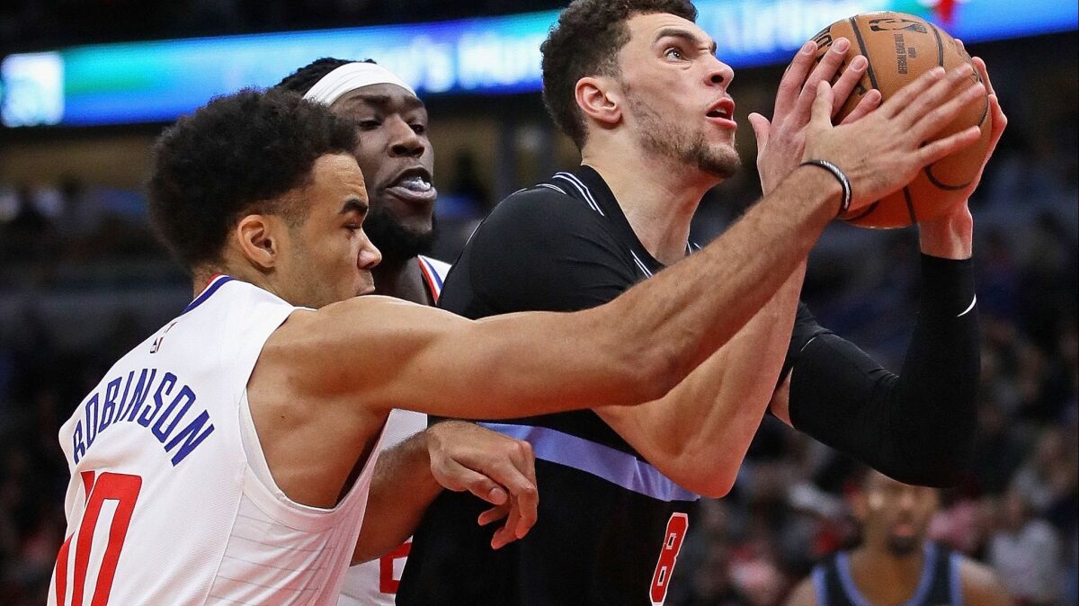 Clippers rookie Jerome Robinson defends with Montrezl Harrell against Zach LaVine last week in Chicago.