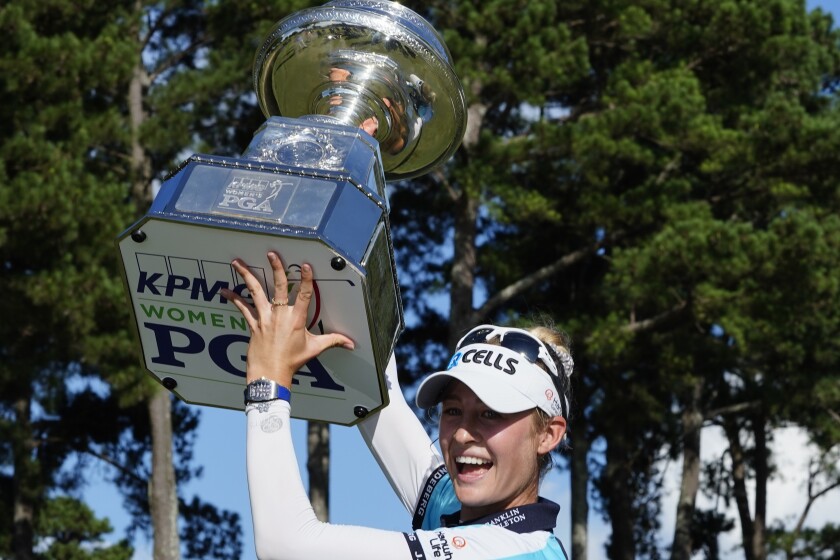 Nelly Korda celebrates by lifting the Women's PGA Championship trophy over her head on Sunday.