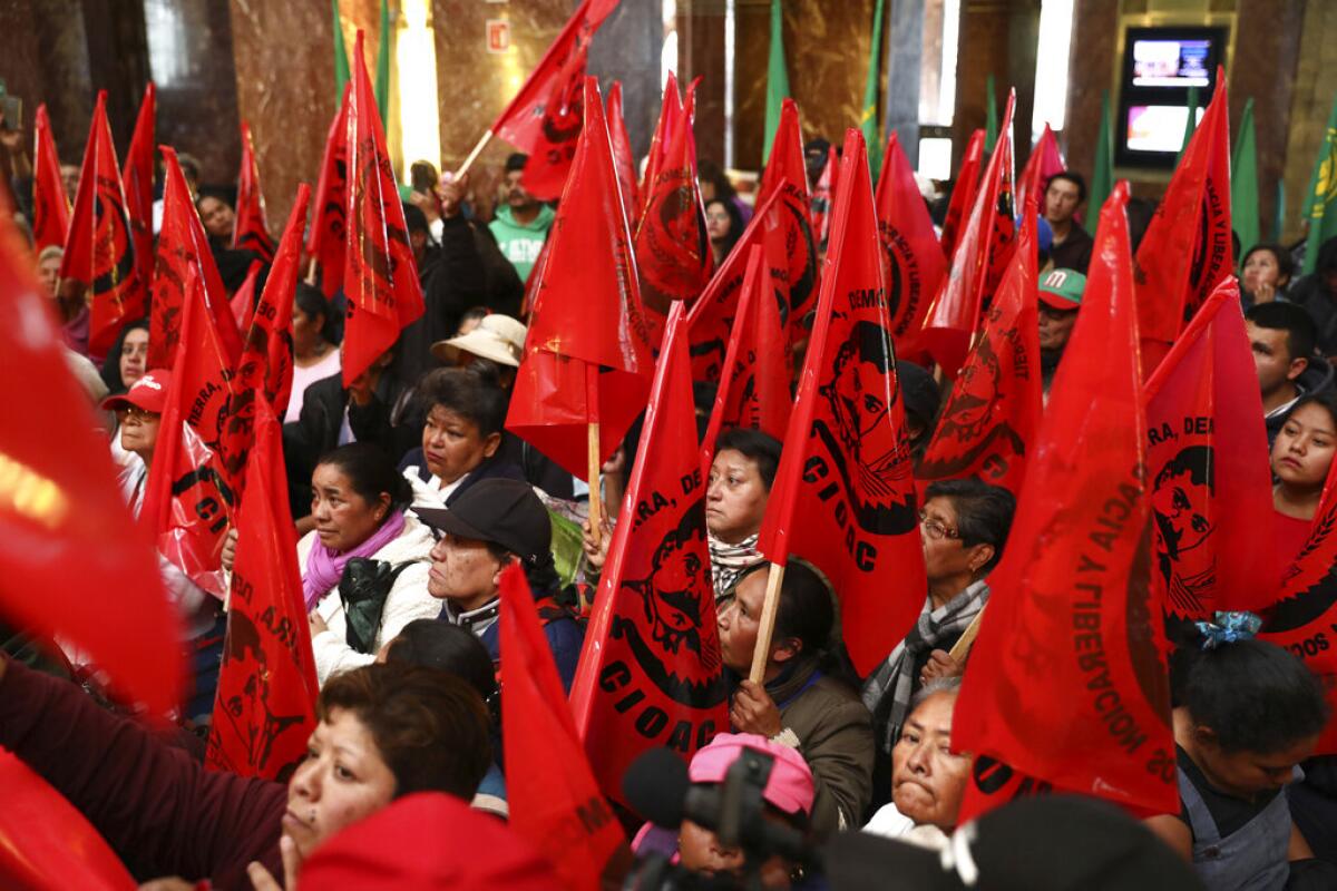 Trabajadores agrícolas bloquean la entrada del Palacio de Bellas Artes para protestar contra una pintura que muestra al revolucionario mexicano Emiliano Zapata desnudo, con tacones altos y sombrero rosado, el martes 10 de diciembre del 2019 en la Ciudad de México. La pintura de Fabián Cháirez forma parte de la exposición “Emiliano. Zapata después de Zapata”, que se presenta en la institución cultural. (AP Foto/Eduardo Verdugo)