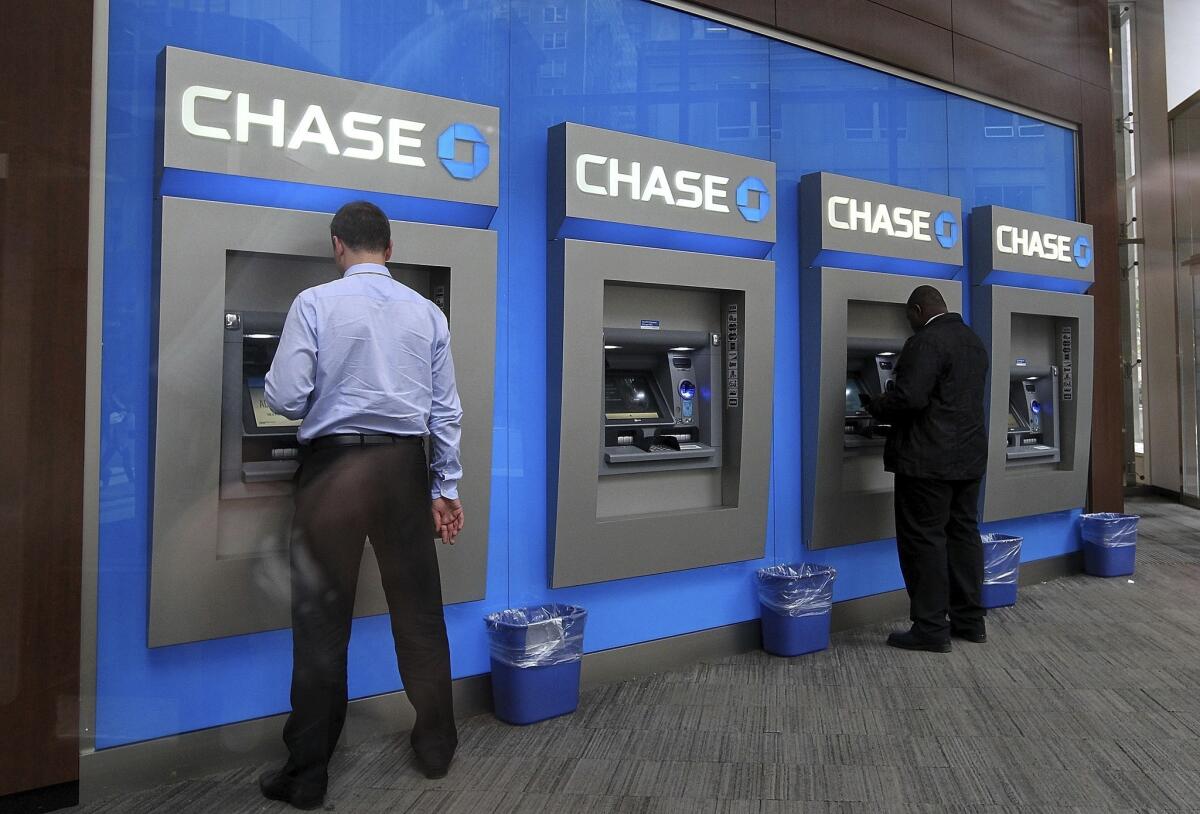 Federal authorities have charged eight men with conspiracy to commit wire fraud by hacking into the networks of banks, including JPMorgan Chase. Above, ATMs at a Chase branch in New York.