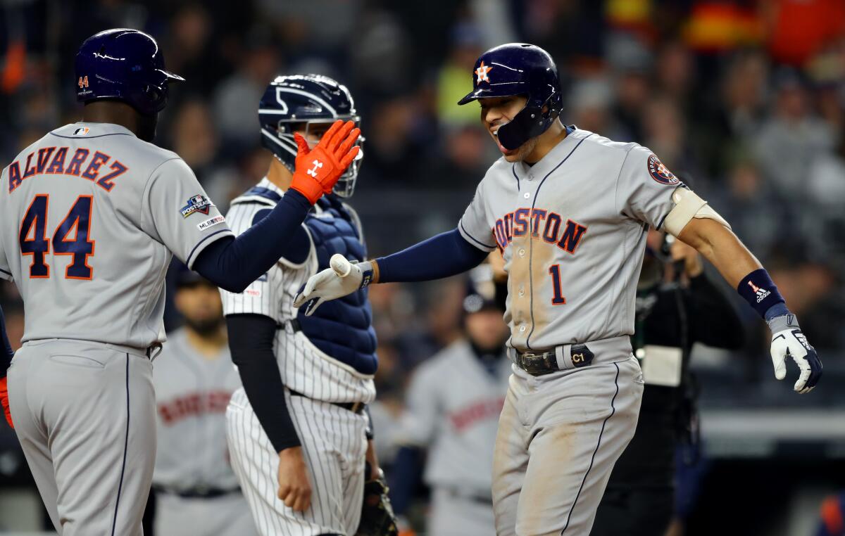 Astros shortstop Carlos Correa celebrates with teammate Yordan Alvarez after hitting a home run.