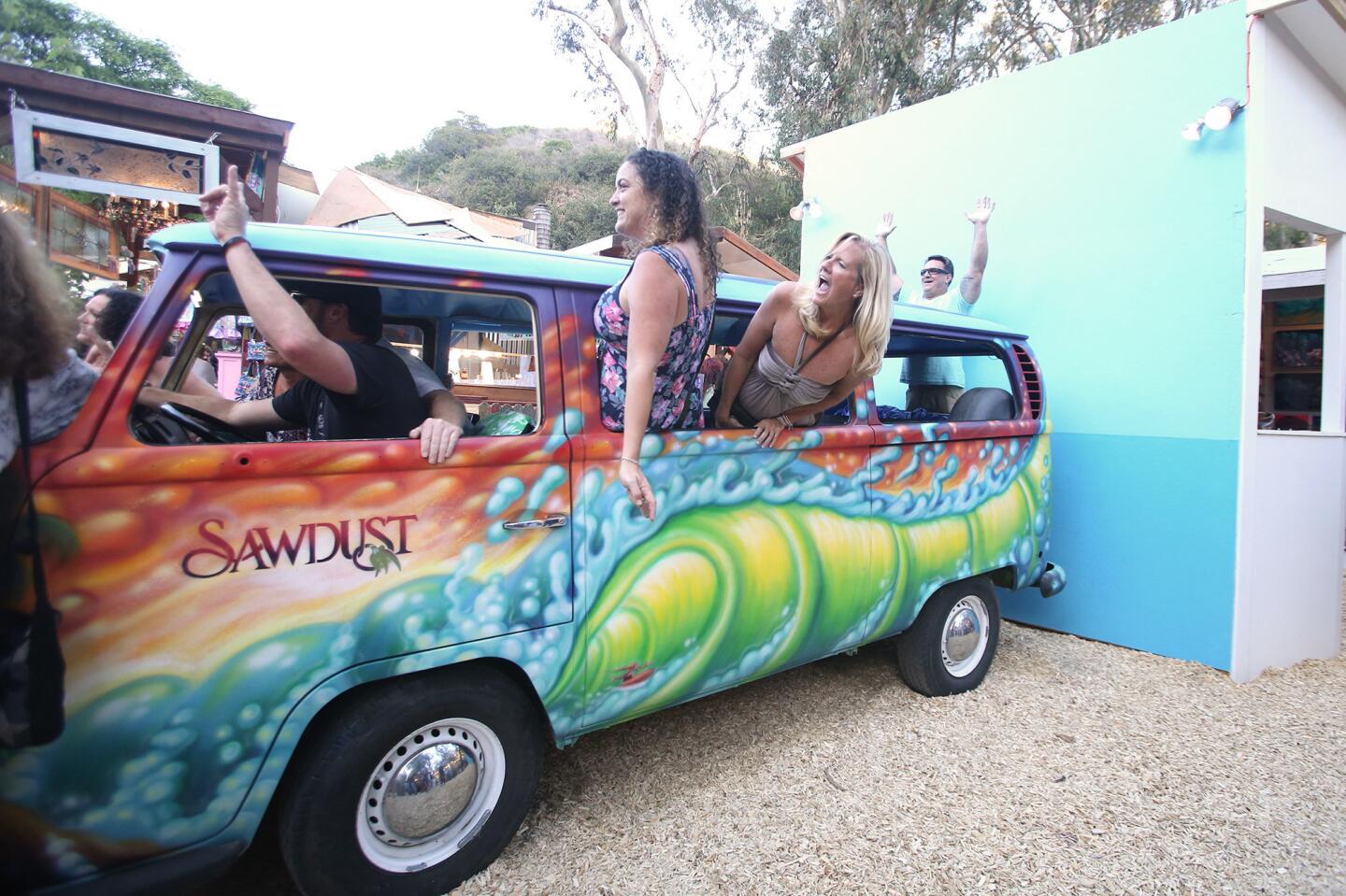 Guests hop aboard the multi-colored Volkswagen bus at Tuesday's Sawdust Art & Craft Festival artist preview night.